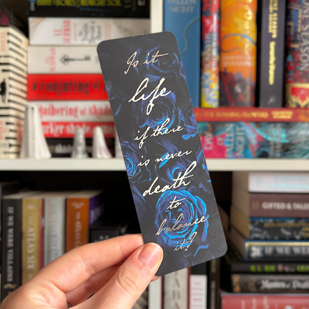 Blue floral bookmark inspired by V. E. Schwab's Bury Our Bones in the Midnight Soil, with foiled text reading "Is it life if there is never death to balance it?"