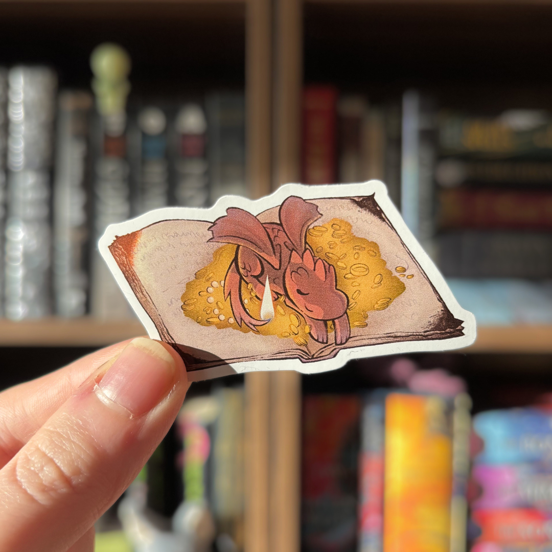Book shaped sticker inspired by the fantasy genre, featuring a dragon lying on a pile of coins atop an open book.