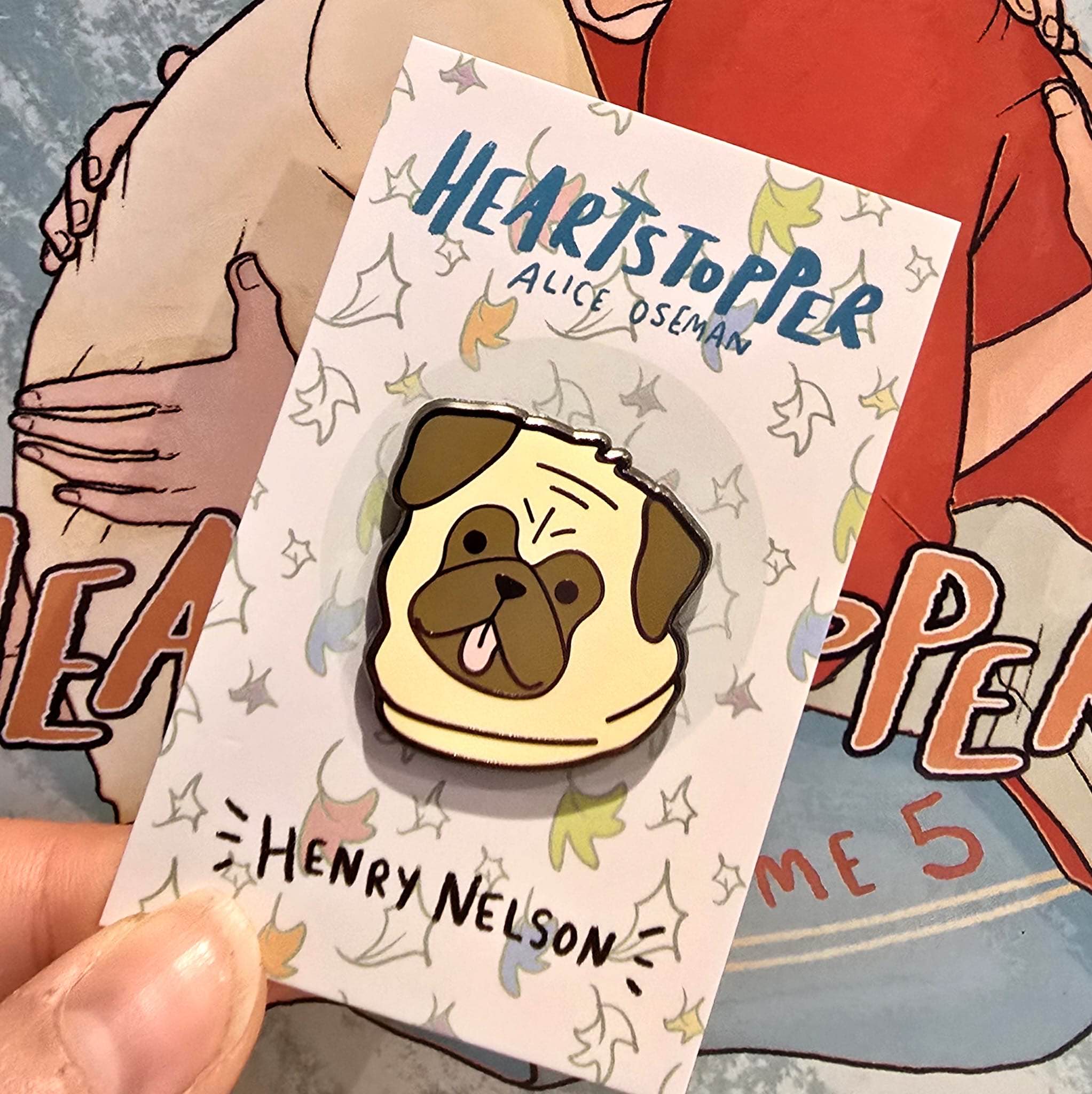 The Henry Nelson enamel pin on Heartstopper backing card. Officially licensed enamel pin by Alice Oseman.