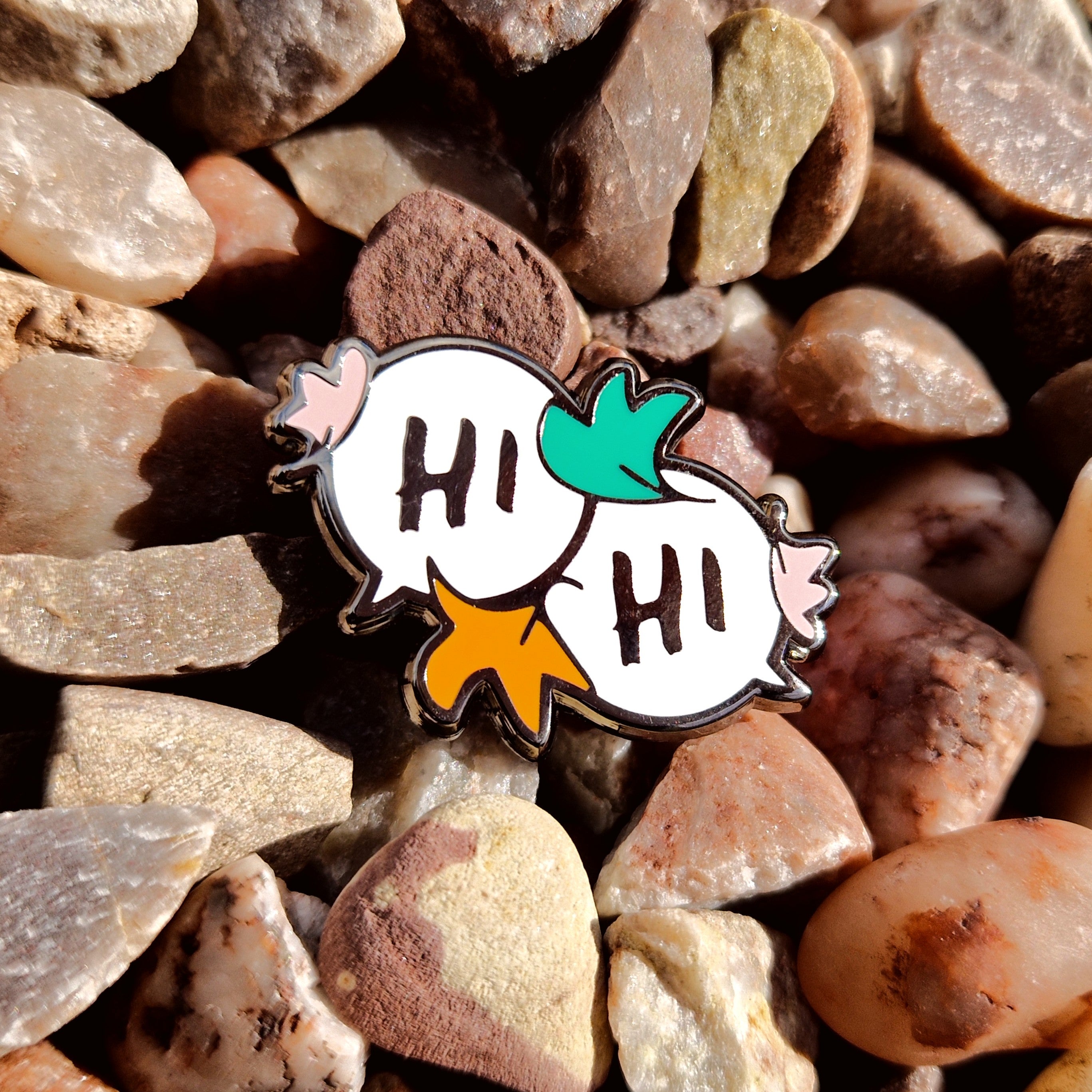 Enamel pin of two speech bubbles with the text "Hi", inspired by Alice Oseman's Heartstopper graphic novels.