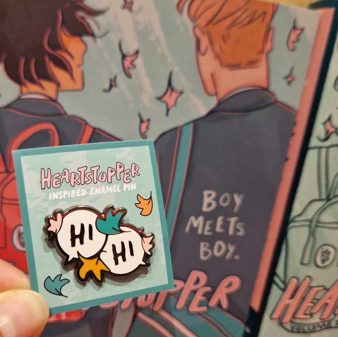 Enamel pin of two speech bubbles with the text "Hi", inspired by Alice Oseman's Heartstopper graphic novels.