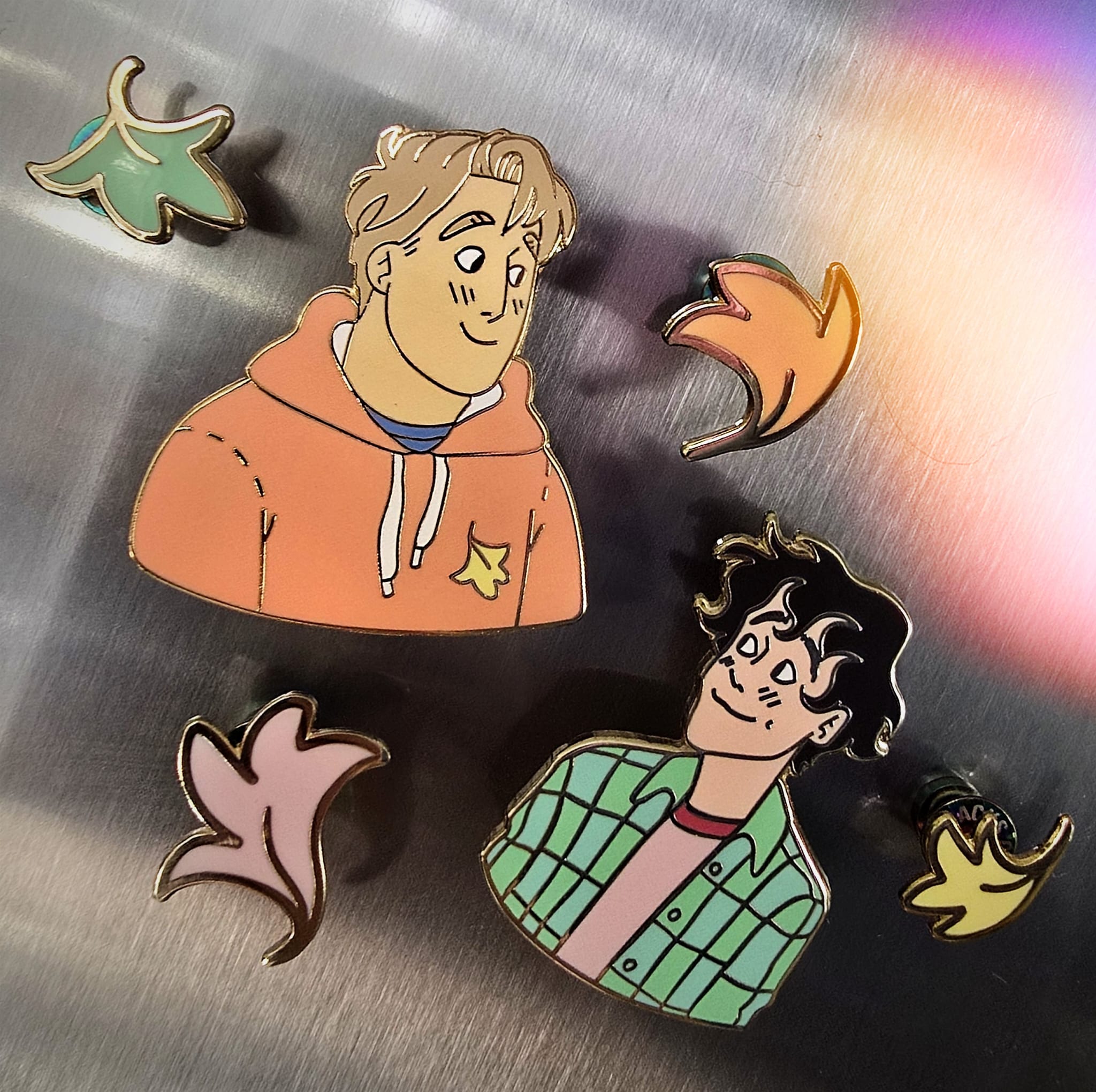 The Officially Licenced Heartstopper Charlie Sping Enamel Pin with Nick and Mini Leaf Collection on the Fridge with the use of Radbacks.