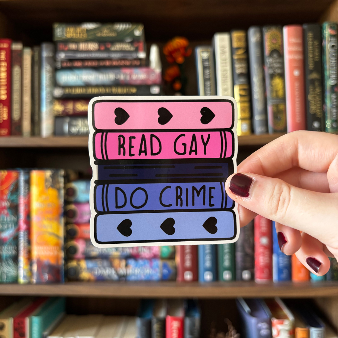 A large sticker designed to look like a stack of books in the colours of the omnisexual pride flag, with text reading "Read Gay Do Crime"