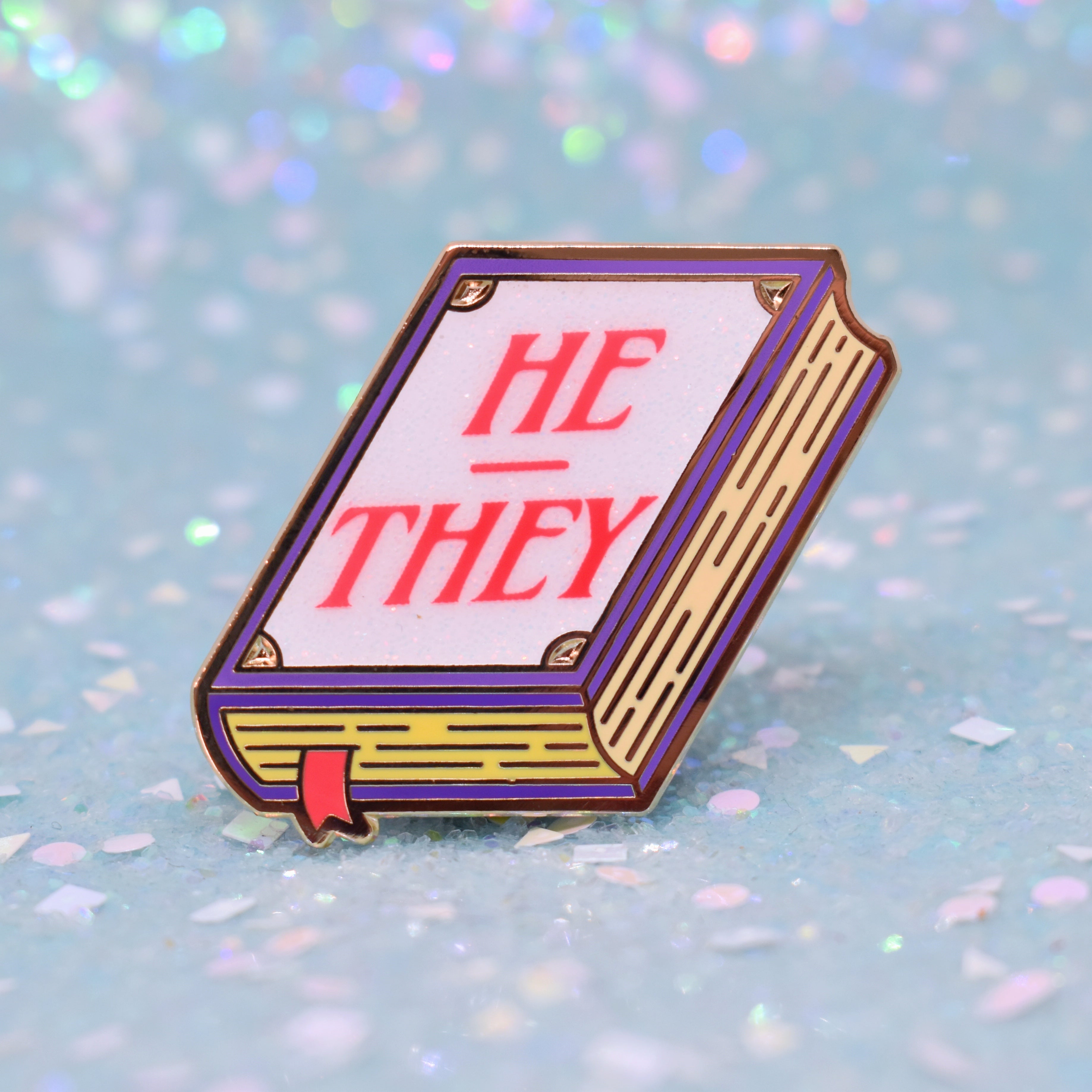 Book shaped pronoun pin on a decorative background