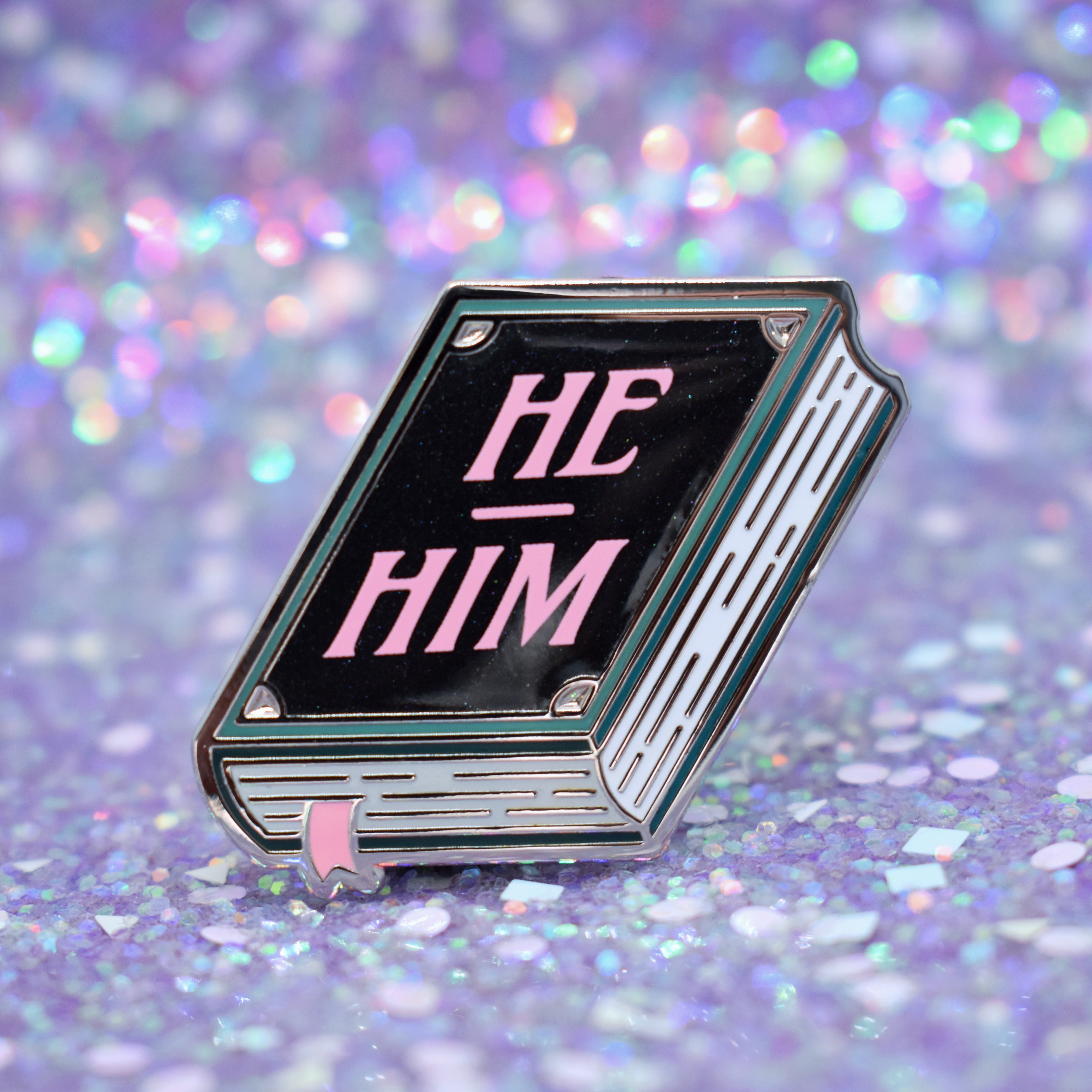 Book shaped pronoun pin on a decorative background
