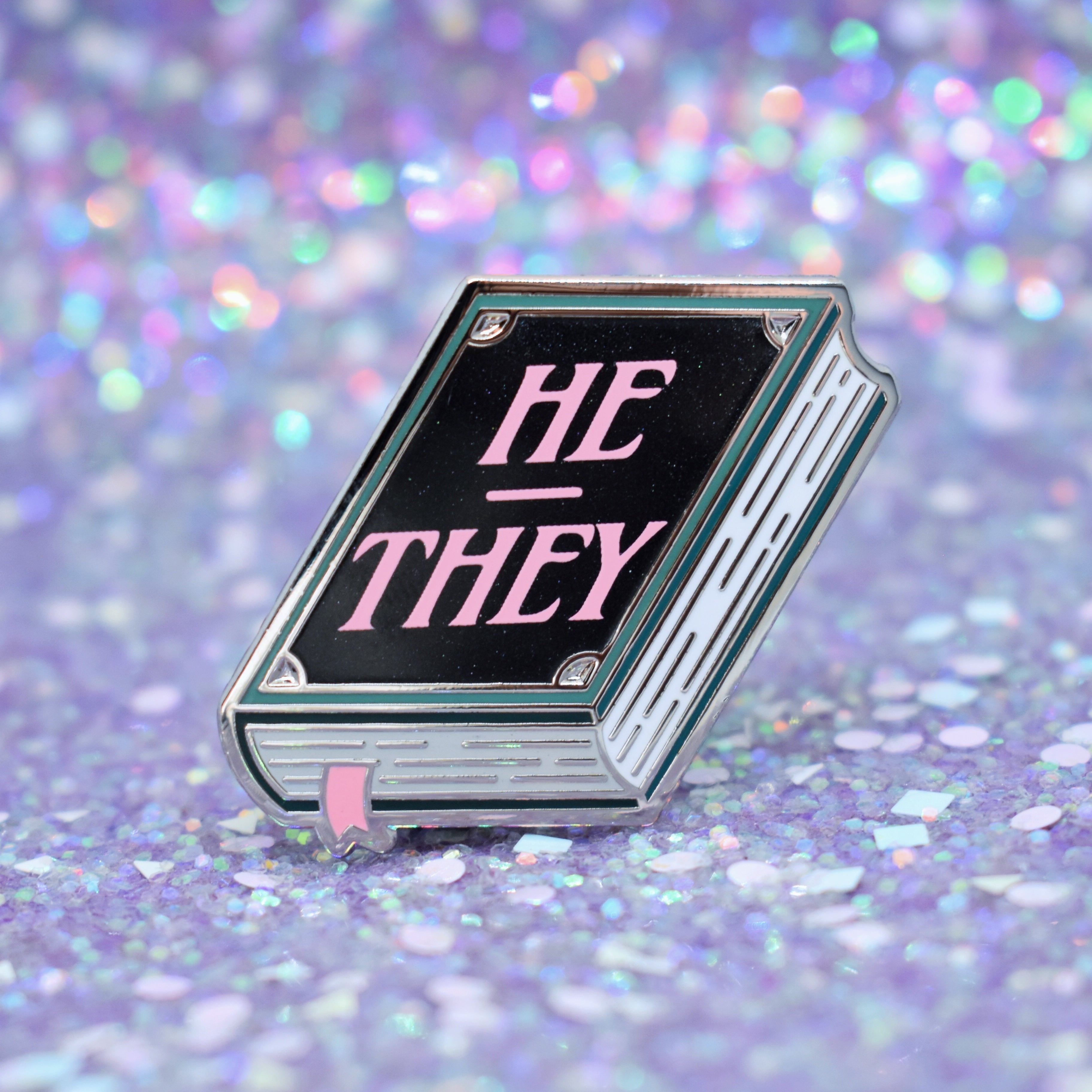 Book shaped pronoun pin on a decorative background