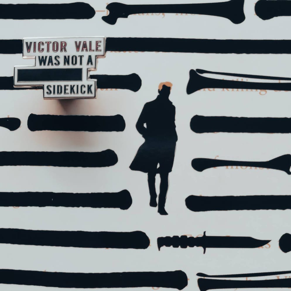Enamel pin inspired by V.E. Schwab's Vicious, featuring the quote "Victor Vale was not a ******* sidekick"