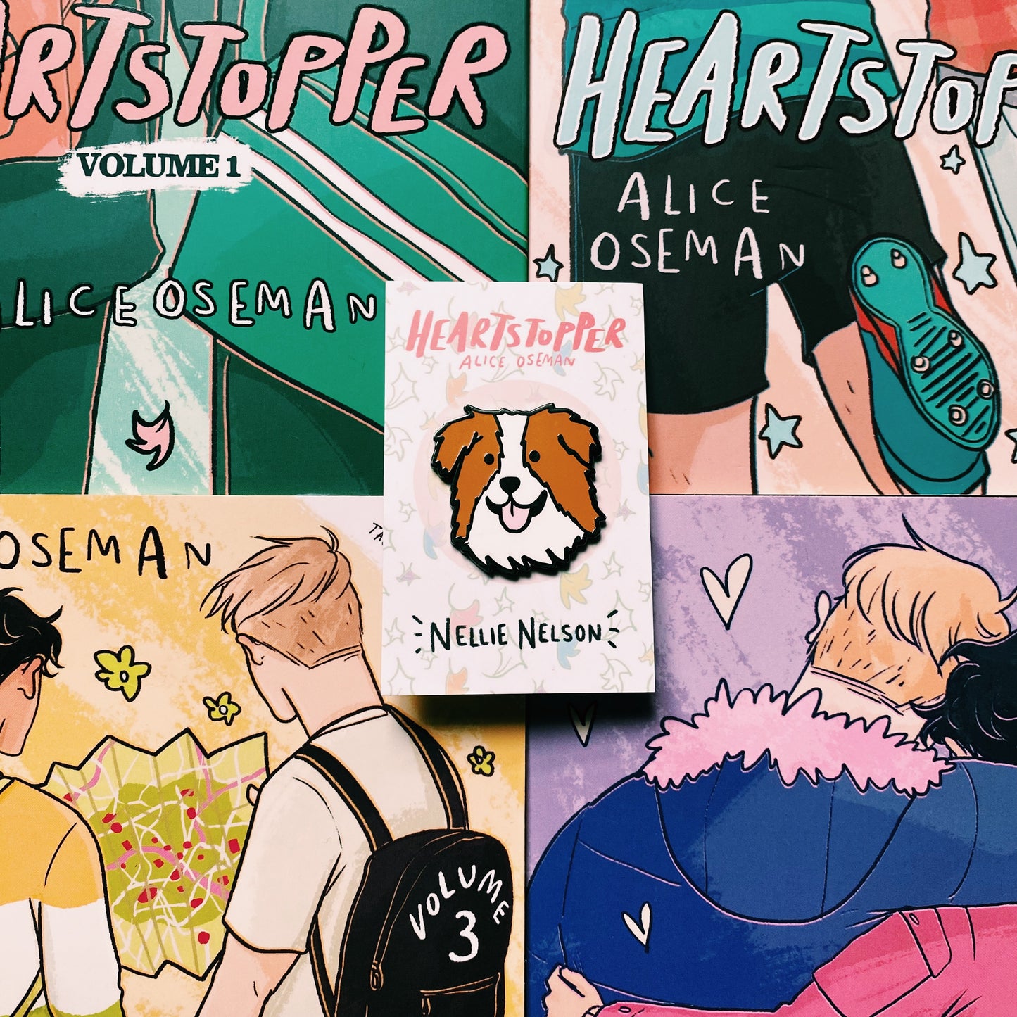 Nellie Nelson enamel pin inspired by Alice Oseman's Heartstopper series. The pin is being held in front of the Hearstopper graphic novels.