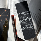 Black bookmark, featuring the quote "Never pray to the gods that answer after dark" displayed on an open book background
