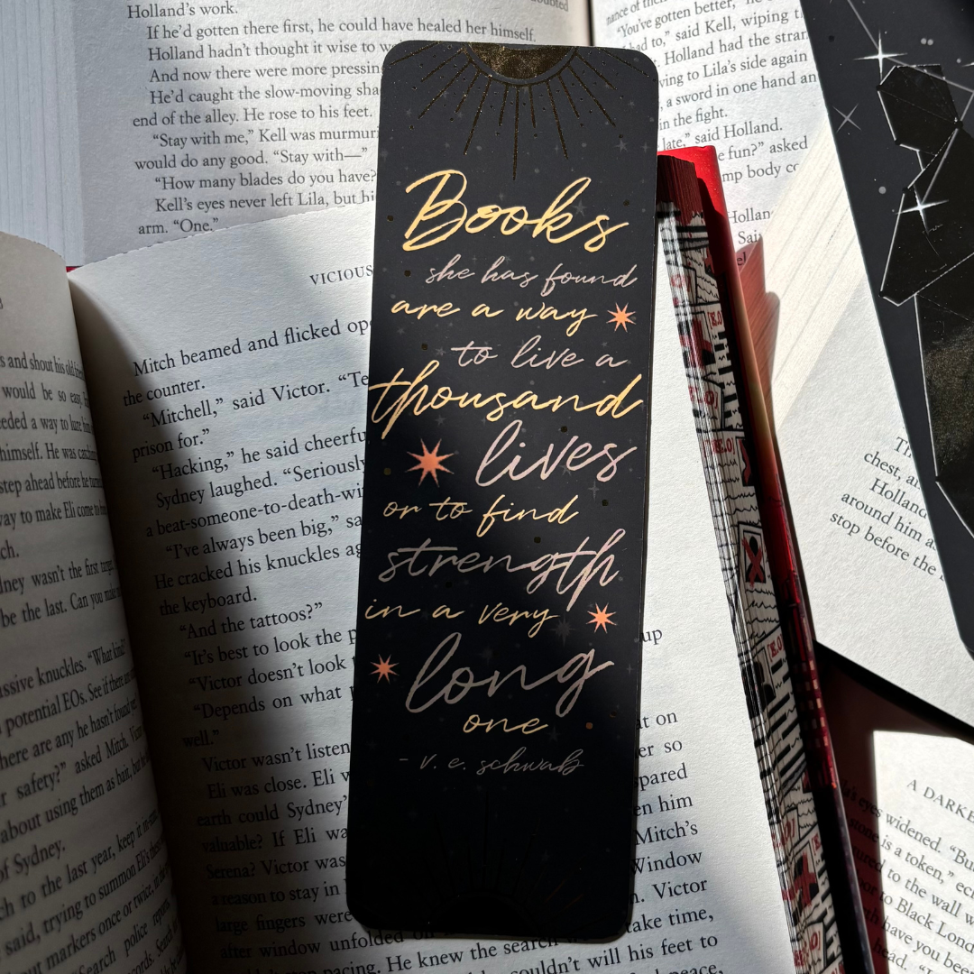 Foiled bookmark inspired by The Invisible Life of Addie LaRue, featuring the quote "Books she has found are a way to live a thousand lives or to find strength in a very long one"