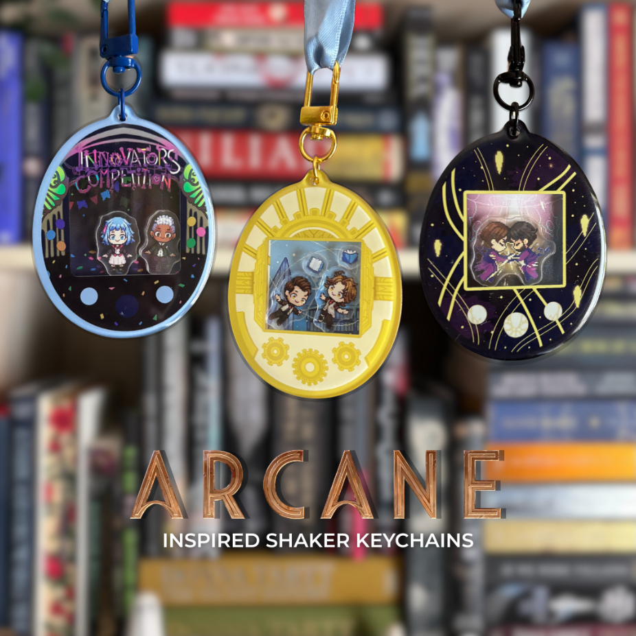 Three Tamagotchi style shaker keychains inspired by TV show Arcane, featuring characters Jayce, Viktor, Jinx, Ekko, and Powder. Held against a bookshelf.