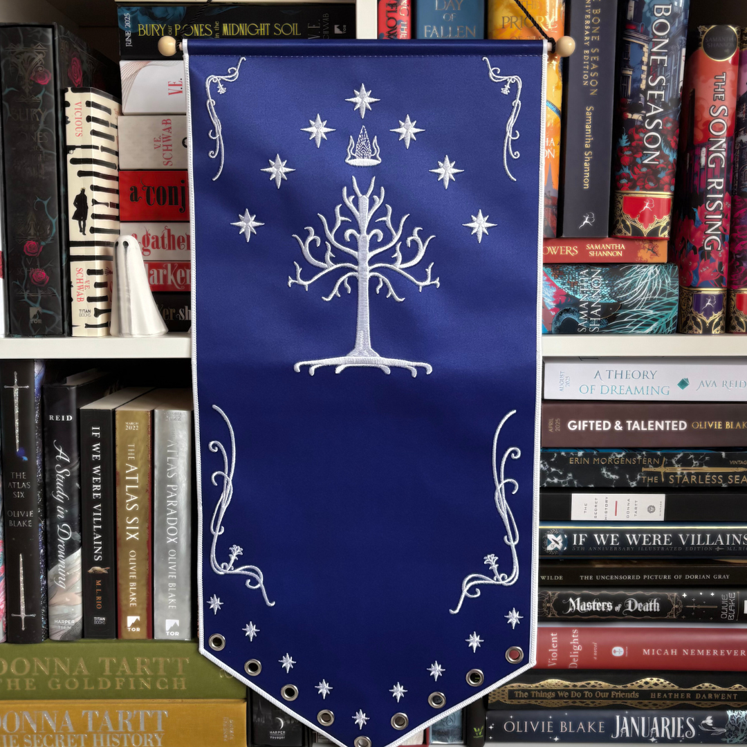 Gondor blue banner with a white tree design and decorative elements. Inspired by Lord of the Rings. Pictured against a bookshelf.