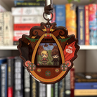 Decorative shaker keychain with characters from the How To Train Your Dragon books in a decorative frame against a bookshelf background