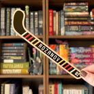 A black bookmark shaped like a hockey stick with text reading "Rozanov". The bookmark is held in front of a blurred bookshelf 