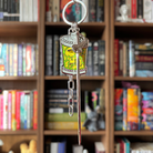 Officially licensed metal keychain featuring a skull charm, a sword charm, and a chain charm.