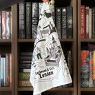 A white tea towel featuring a design of "Lockwood & Co's London," showing landmarks from the series and ghosts.