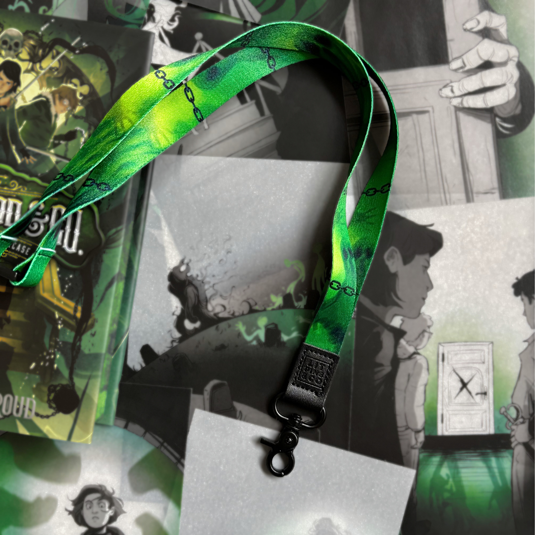 LitPins&Co officially licensed Lockwood&Co lanyard, photographed against a background of Lockwood&Co page overlays. The lanyard is green and features a design of chains and ghosts.