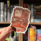 Book shaped sticker inspired by the crime genre, featuring a locked and blood stained book.