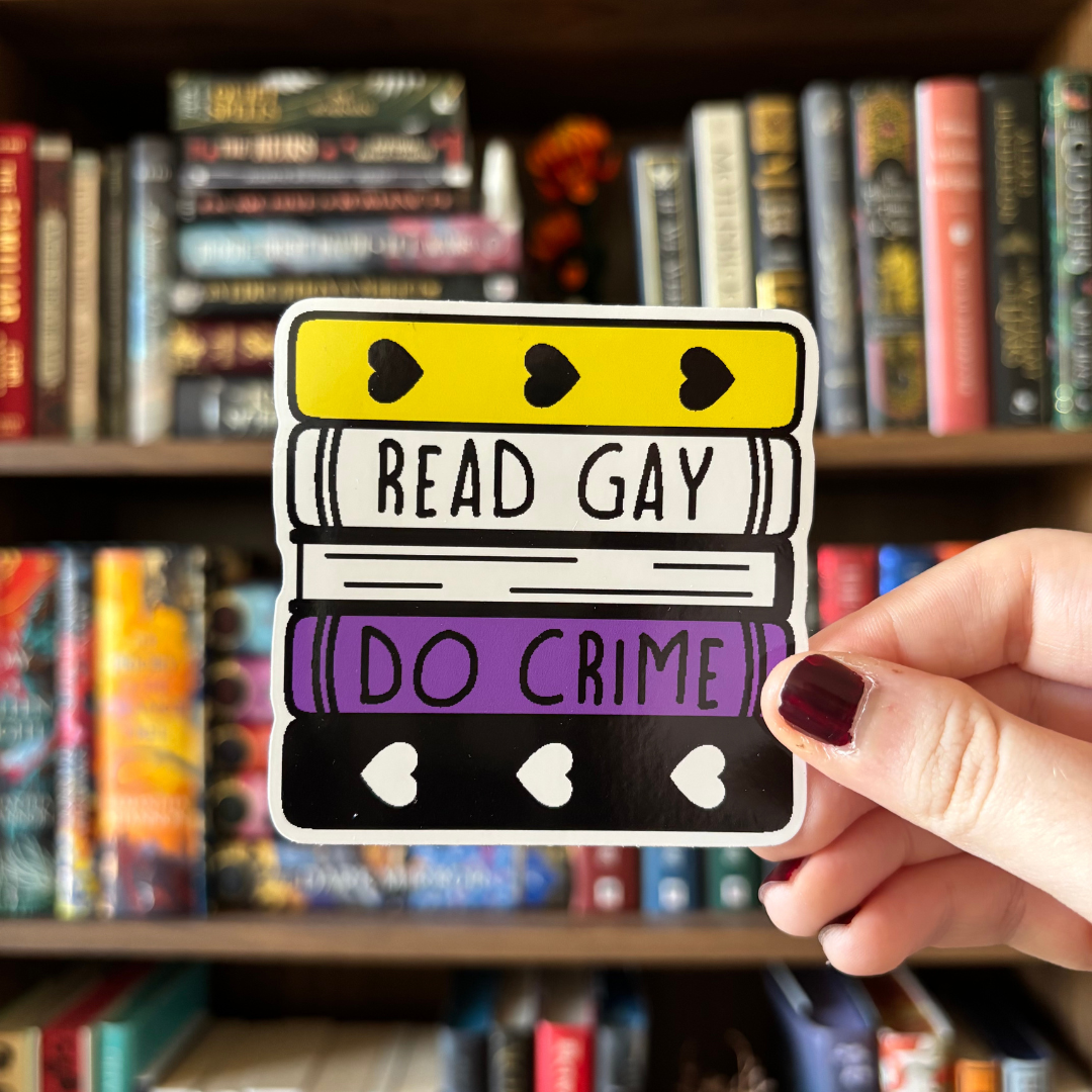 A large sticker designed to look like a stack of books in the colours of the non-binary pride flag, with text reading "Read Gay Do Crime"