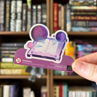 Book shaped sticker inspired by the Sci-Fi genre, featuring a screen displaying holograms of planets .