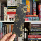 Black foiled bookmark decorated with golden suns inspired by Leigh Bardugo's Grishaverse series