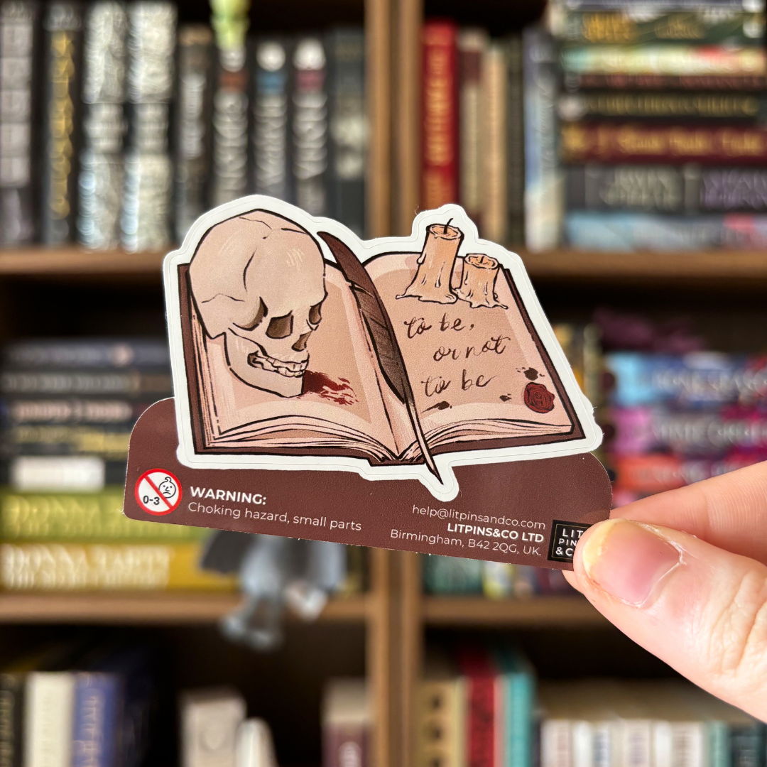 Book shaped sticker inspired byShakespeare plays, featuring a Shakespeare quote, a skull, some candles, and a quill on an open book.