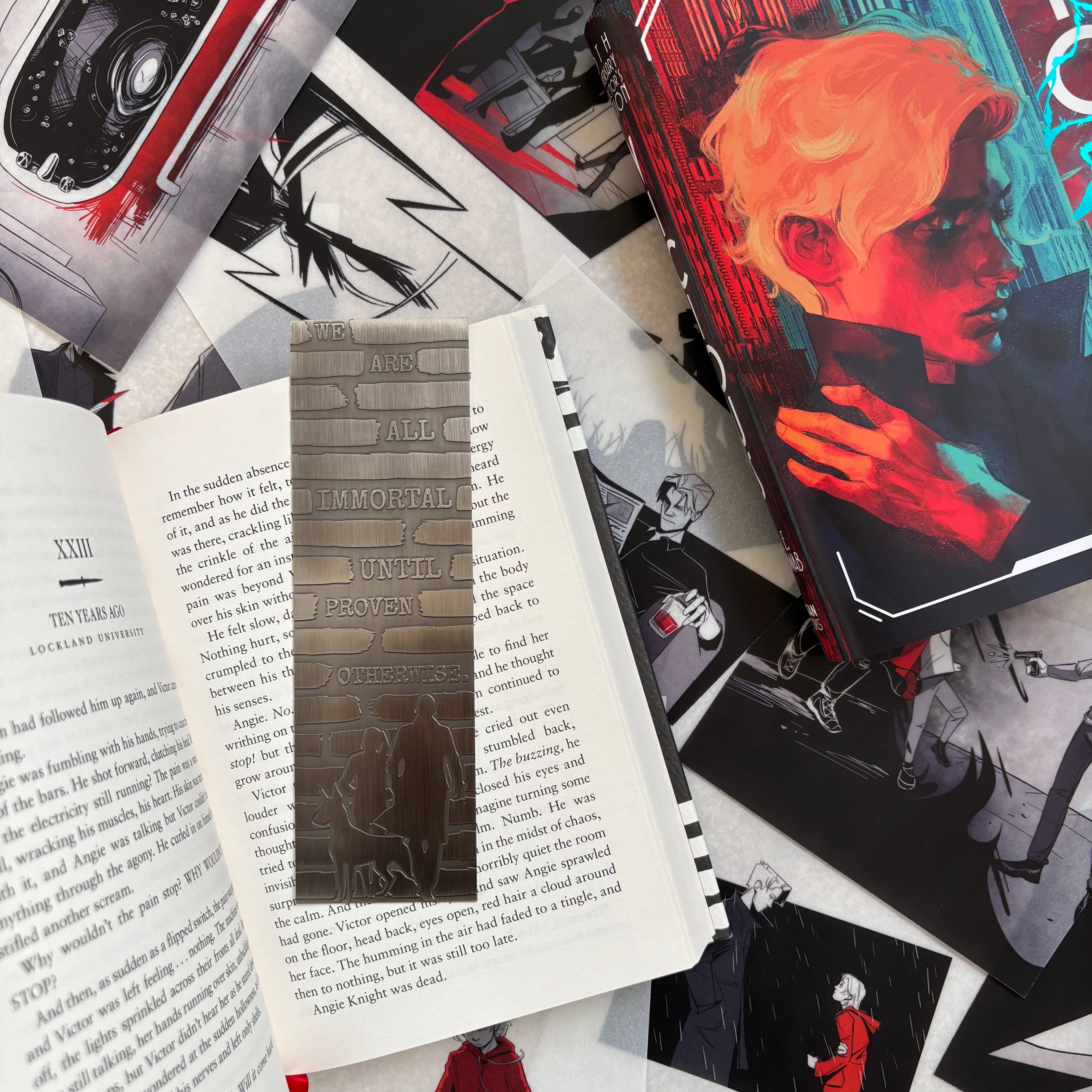 Vicious limited edition ten year anniversary metal bookmark rest on an open cover of the book with the quote: "We are all immortal until proven otherwise."