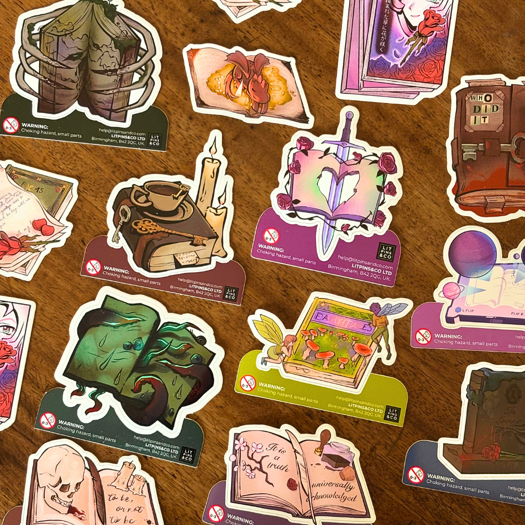 A selection of book shaped stickers themed around various genres, pictured on a wooden background.