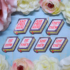 Set of book shaped pronoun pins on a decorative background with flowers