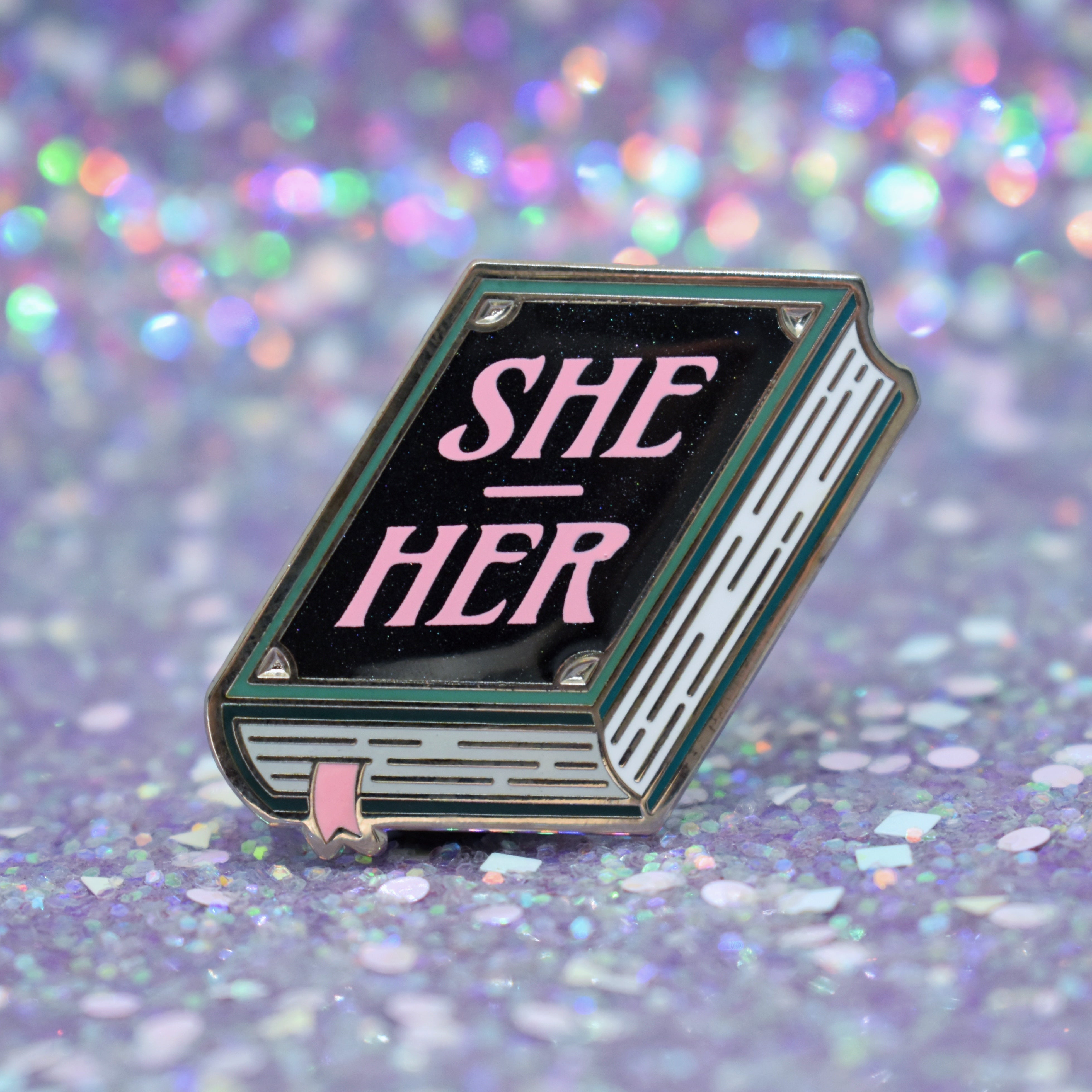 Book shaped pronoun pin on a decorative background 
