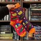 Purple and red socks with a book pattern