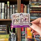 Book-shaped sticker with the text "Read with pride" decorated in colours of various pride flags
