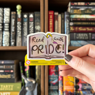 Book-shaped sticker with the text "Read with pride" decorated in colours of various pride flags