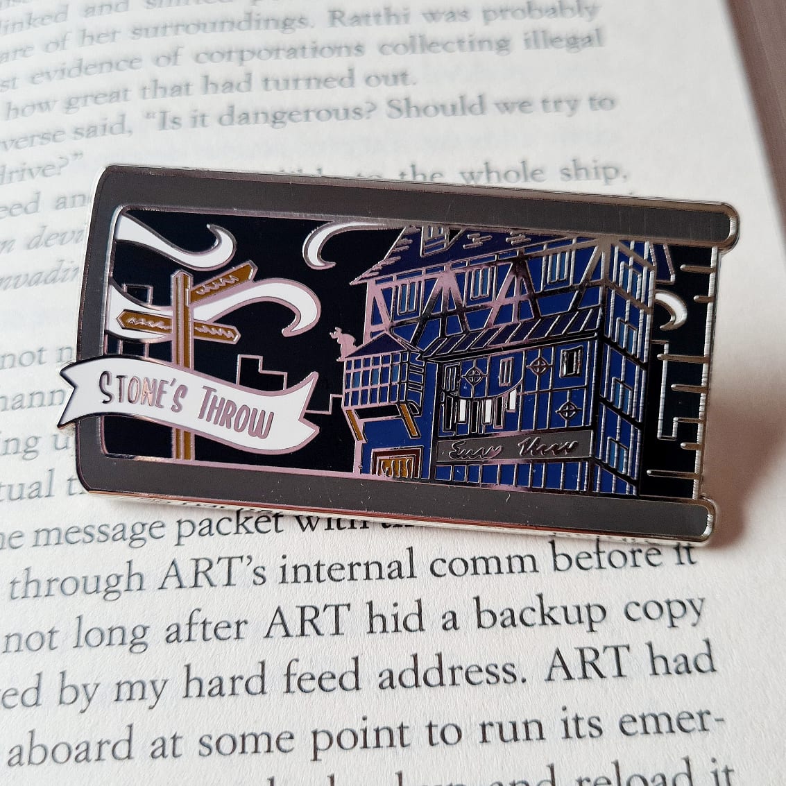 Inspired by V. E. Schwab's A Darker Shade of Magic series, a build your own book stack enamel pin featuring Stone's Throw.