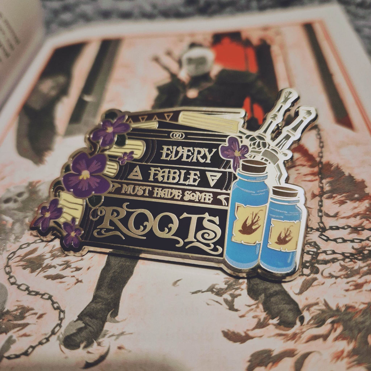 The Witcher inspired Story Stack enamel pin featuring the quote Every Fable Must Have Some Roots.