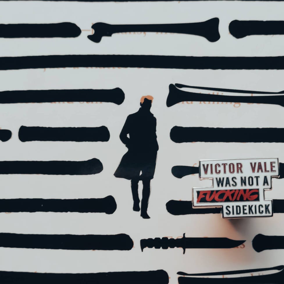 Enamel pin inspired by V.E. Schwab's Vicious, featuring the quote "Victor Vale was not a ******* sidekick"